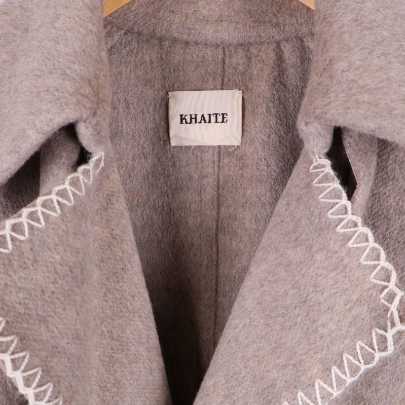 Närbild på krage och Khaite-märke med vita sömmar