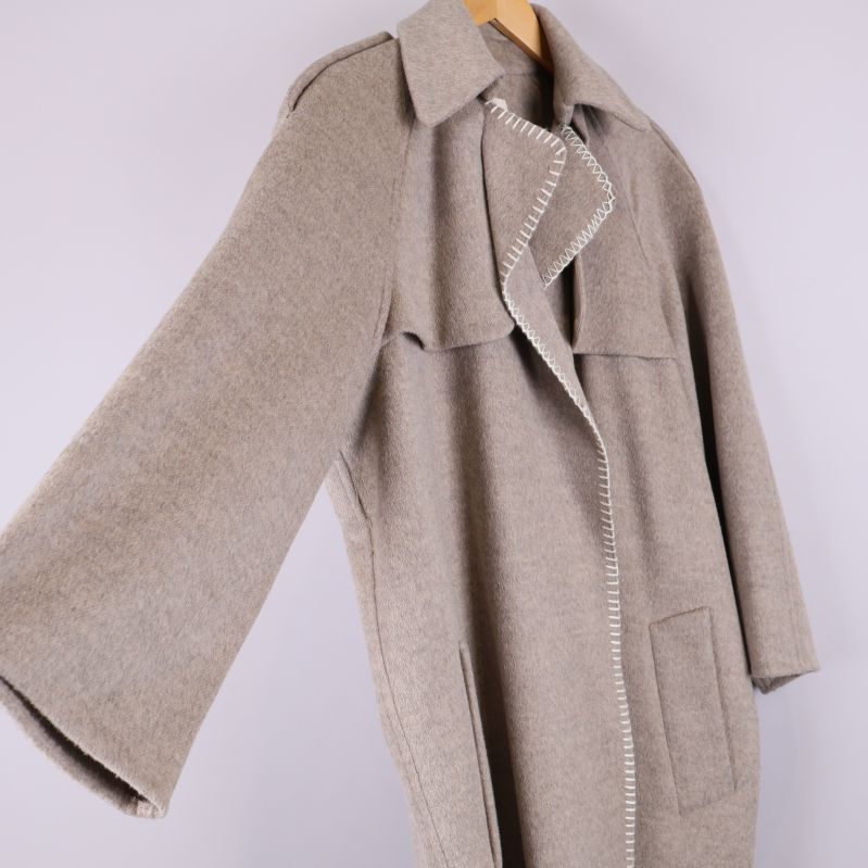 Ärm och framficka på beige kappa i ullmix