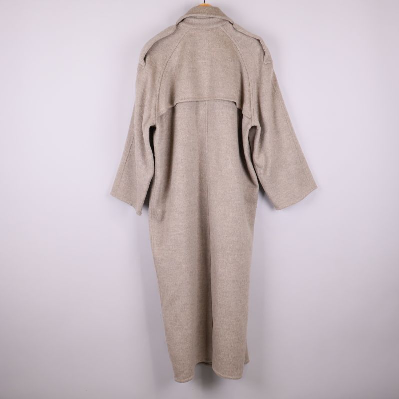 Baksidan av beige långkappa med bred axelok