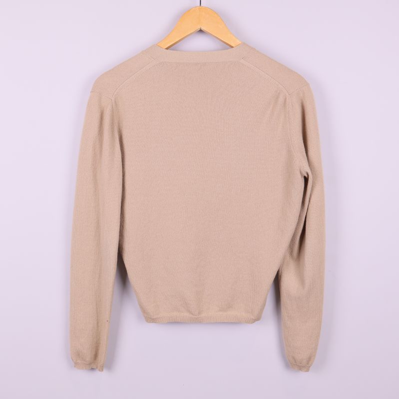 Baksida av beige stickad kofta