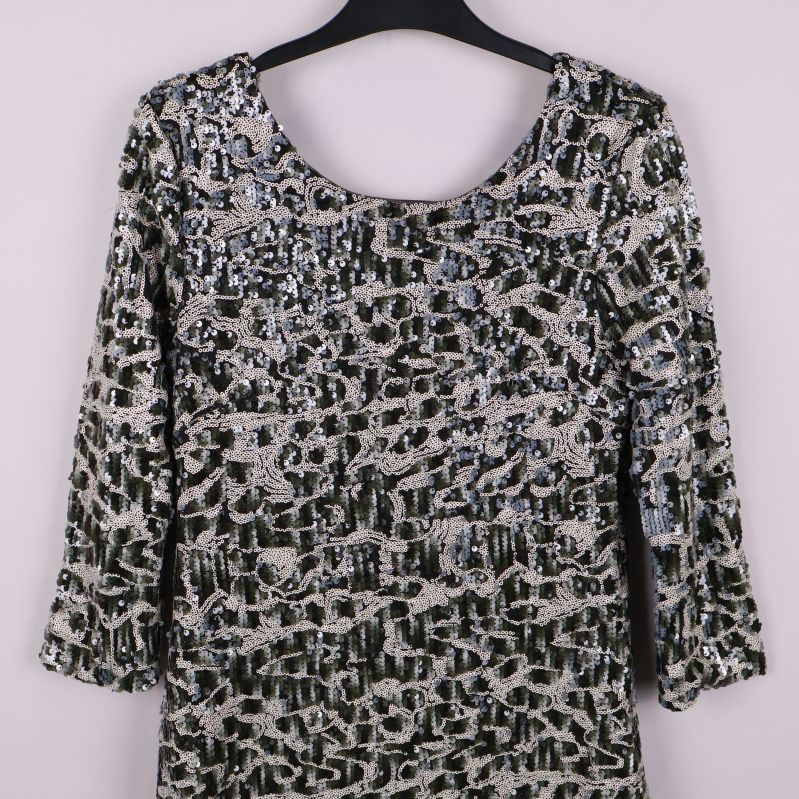 Närbild på överdelen av paljettklänning med mönster