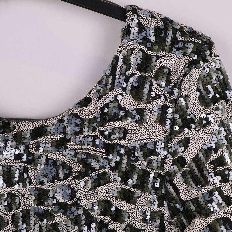 Närbild på paljettytan och halsringningen