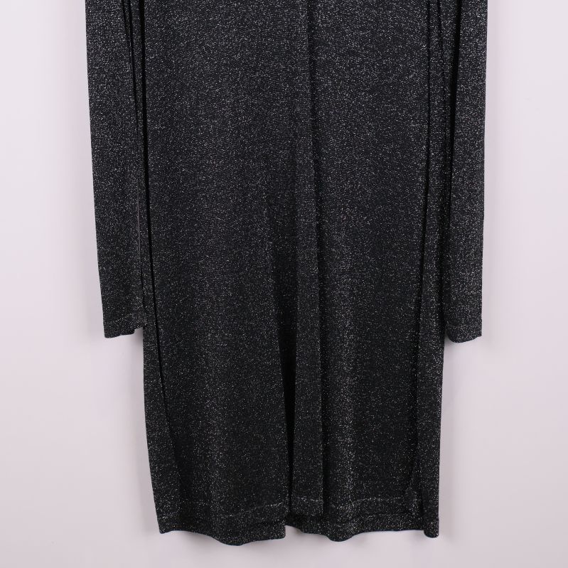 Nedre delen av svart glittrig klänning med synliga sömmar