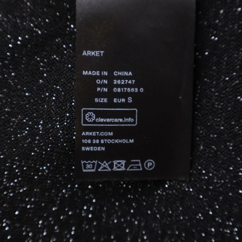 Etikett med tvättråd och Arket-märke