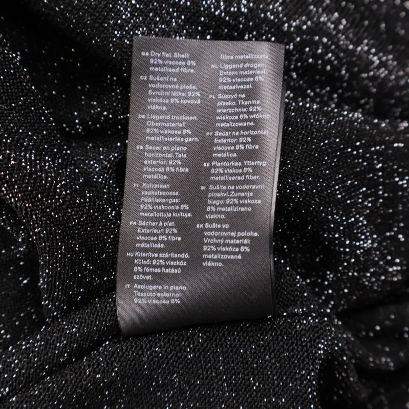 Materialetikett i svart klänning i flera språk