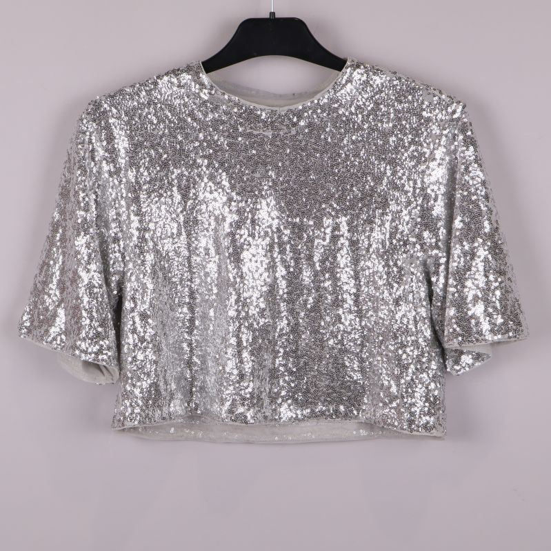 Framsidan av silvrig paljettopp