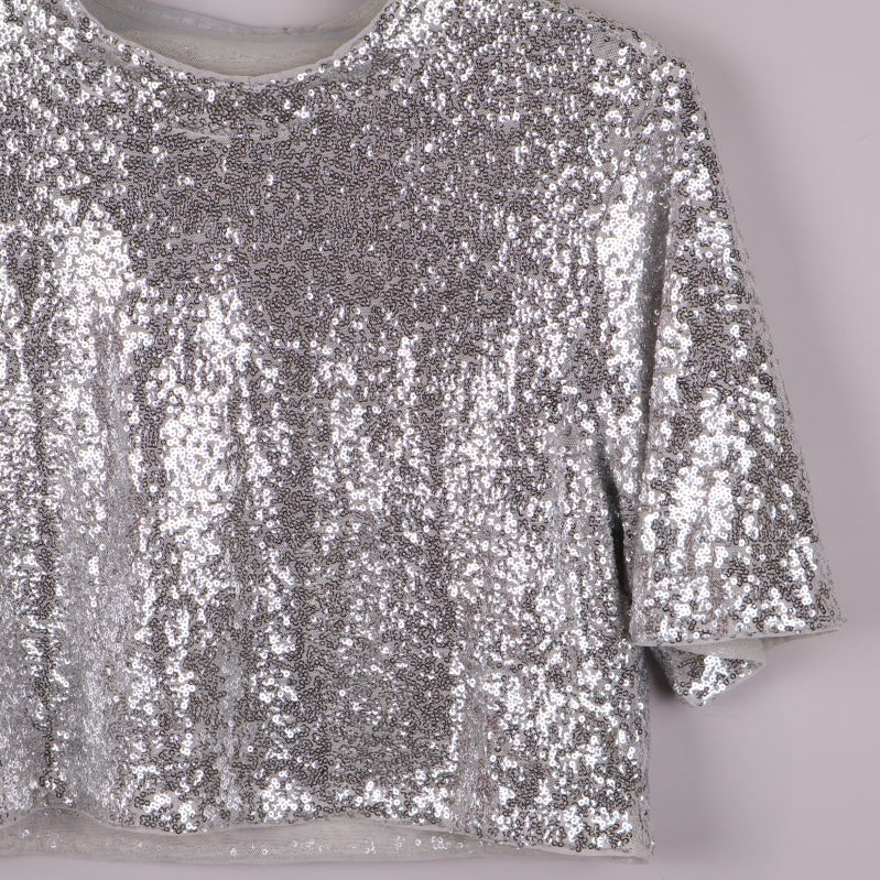 Detalj av axel och ärm på silvrig paljettopp
