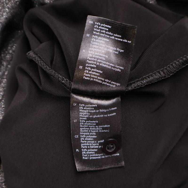 Tvättrådsetikett med materialinformation på insidan