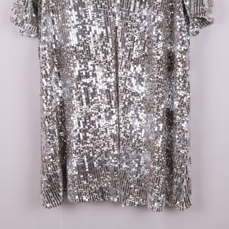 Nedre del av tunikan med täckande silverpaljetter och rak fåll