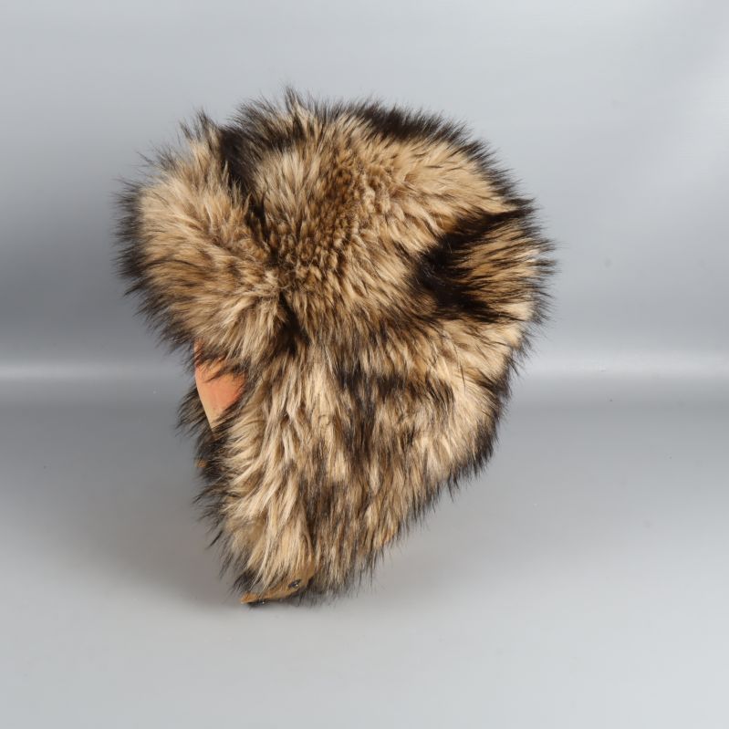 Fuskpälsmössa fotograferad från andra sidan på trähuvud