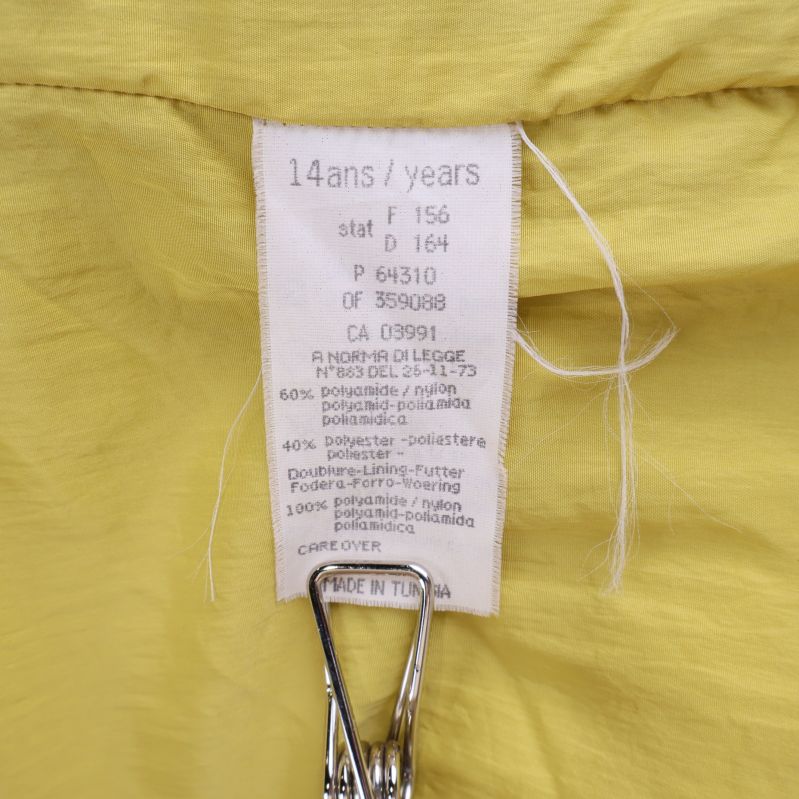 Detaljerad materialetikett med procentinnehåll på insidan av kappan