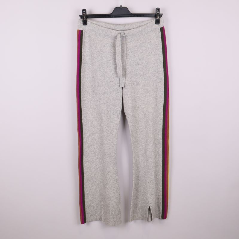 Grå stickade byxor med färgglada ränder sedd framifrån