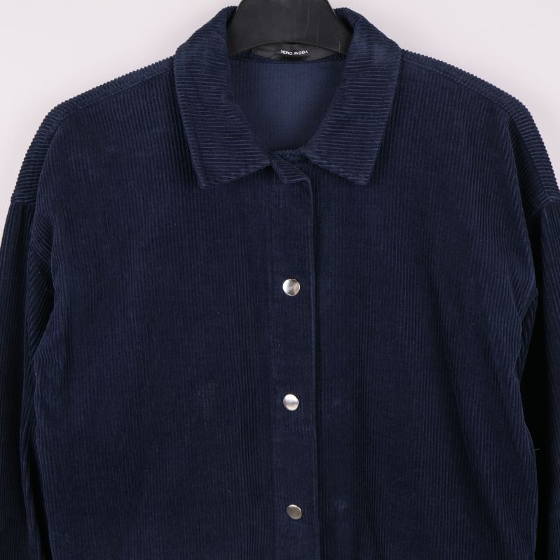 Närbild på krage och knappar i manchestertyg