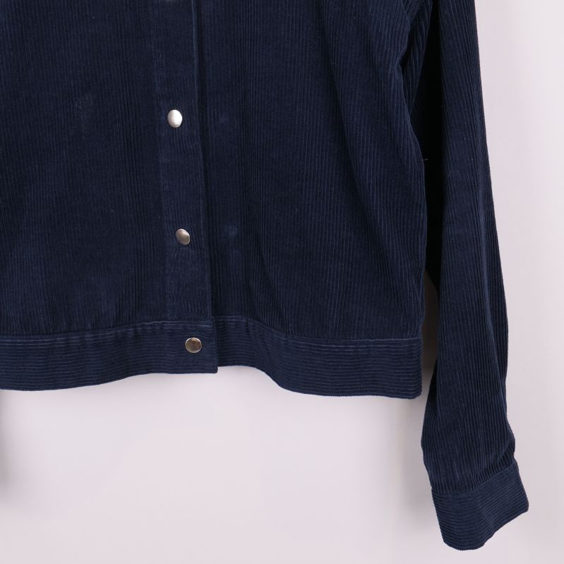 Närbild på jackans nedre högra framkant och ärmslut