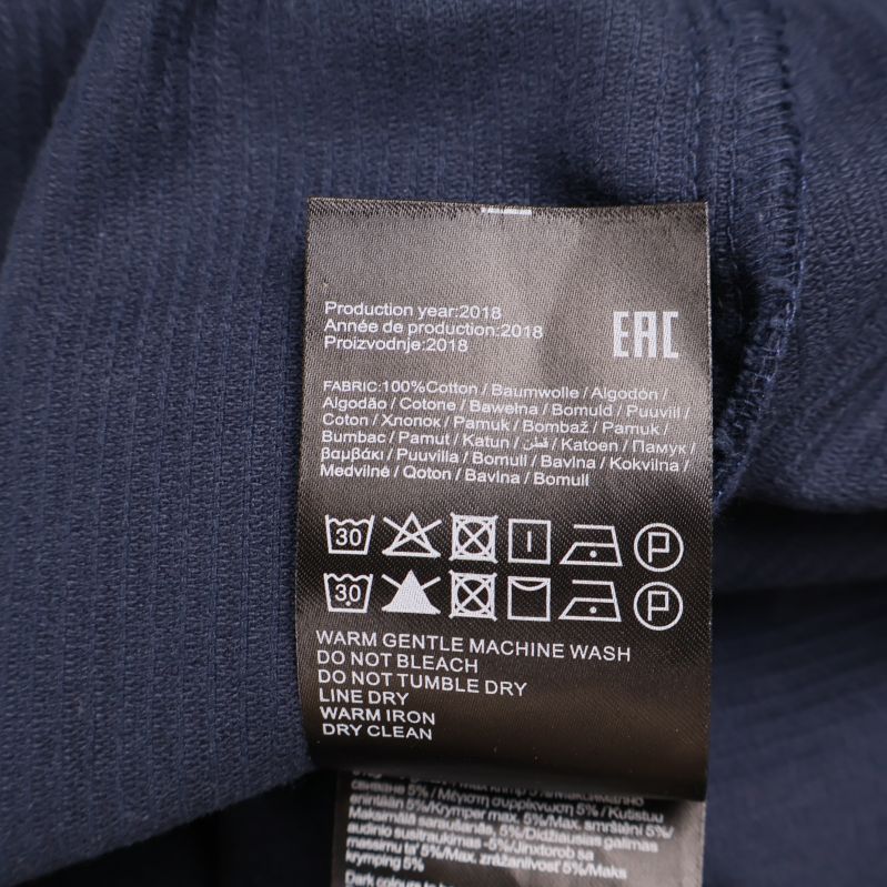 Svart materiallapp med information om material och tvättråd