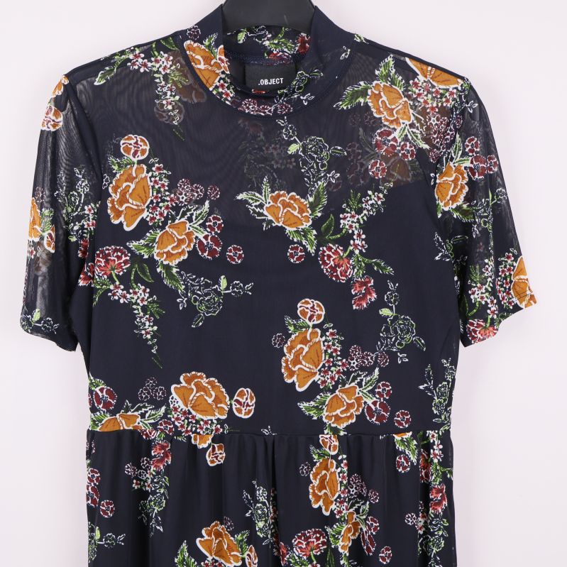 Övre del av blommig meshklänning med transparent tyg
