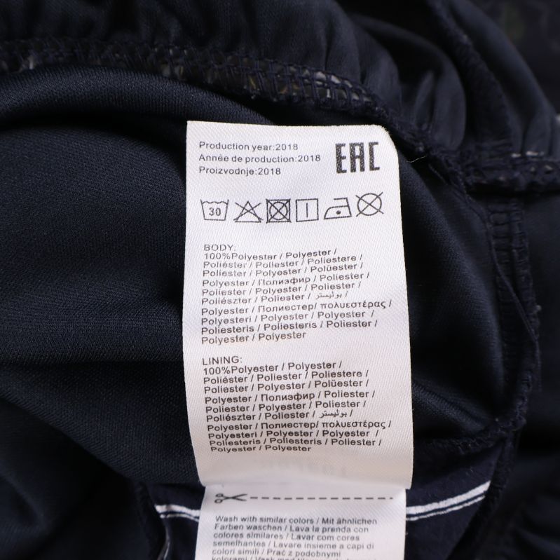 Materialetikett med text om polyester och skötselråd
