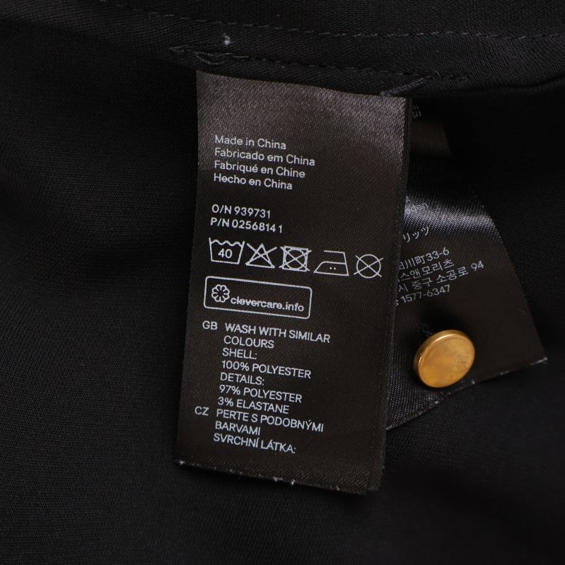 Material- och skötselrådsetikett för svart blus