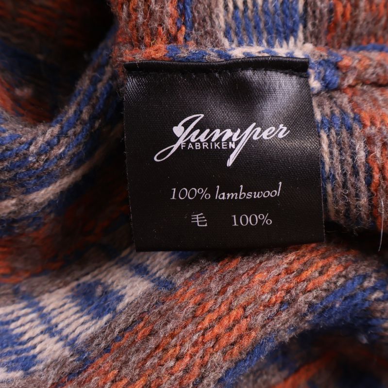 Materiallapp med texten 100% lammull Jumperfabriken