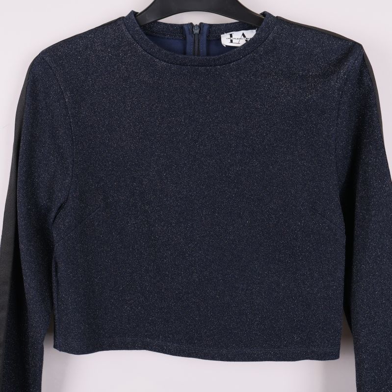 Närbild på framsidan av glittertoppen och halsringningen