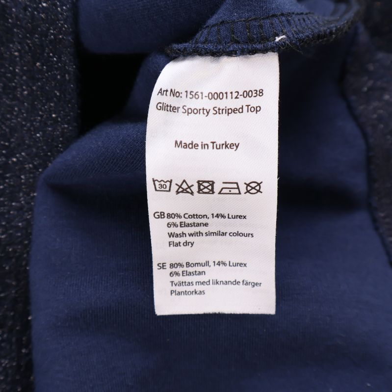 Materiallapp visar 80% bomull, 14% lurex, 6% elastan