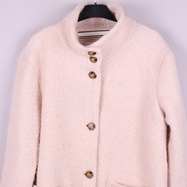 Närbild på kappans överdel med knappar och krage