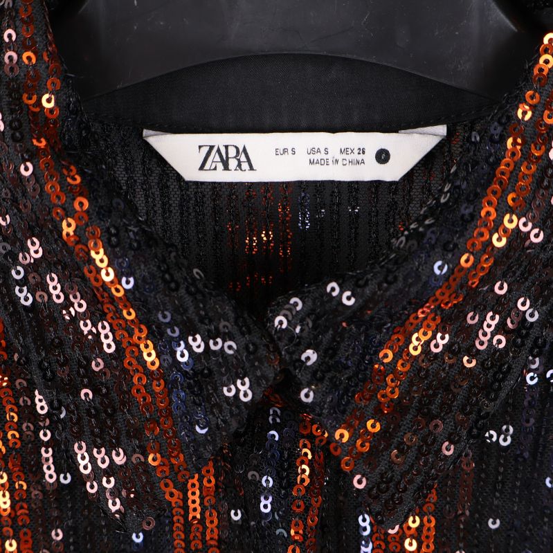 Närbild på märkesetikett Zara i plagget