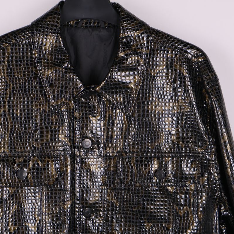 Närbild på axlar och bröstfickor med ormmönster