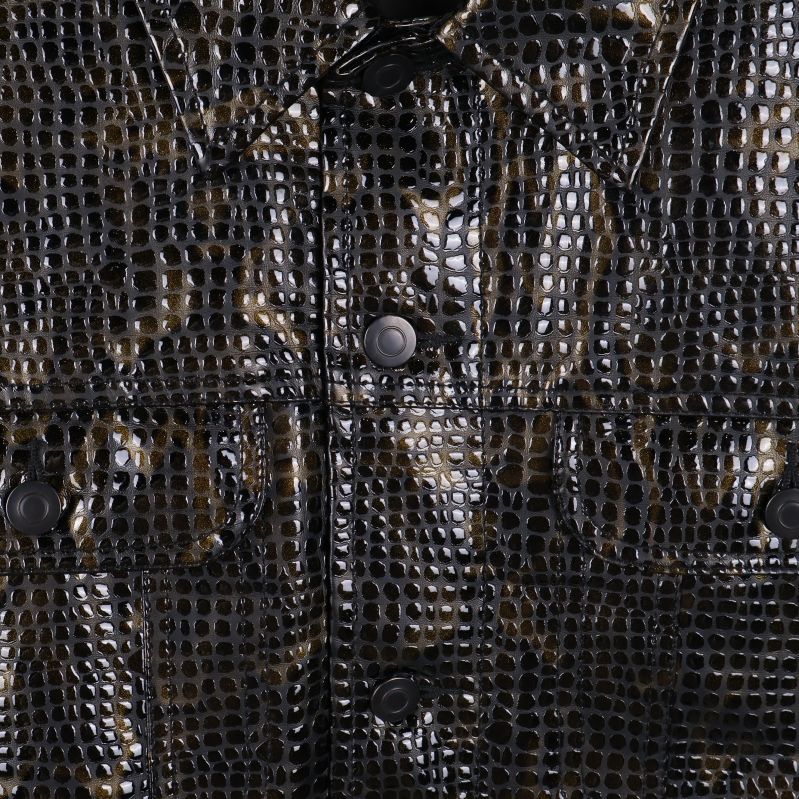 Närbild på blankt ormmönstrat tyg och knappar