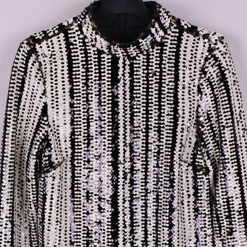 Närbild av hög krage och paljettmönster på blus