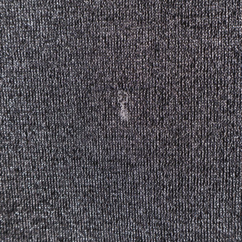 Närbild lös tråd och litet slitage