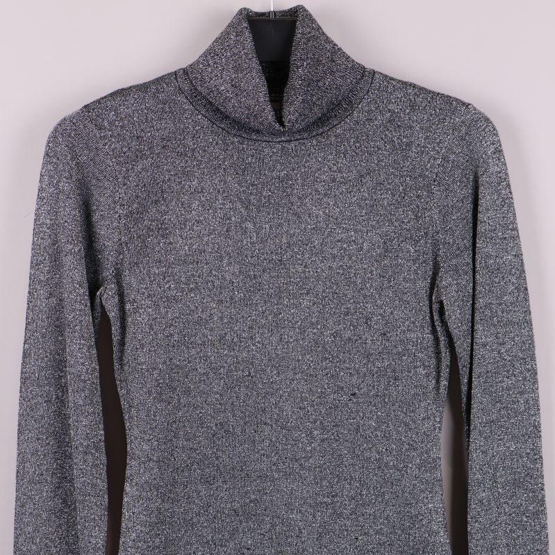 Övre del av glittrig polotröja med hög krage