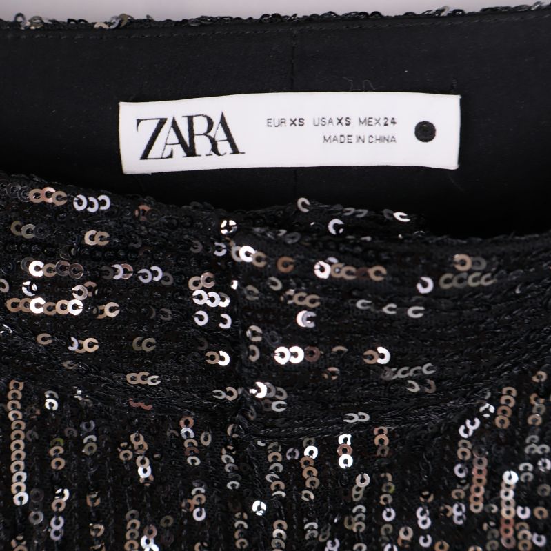 Närbild på Zara-etikett och paljetter i midjan