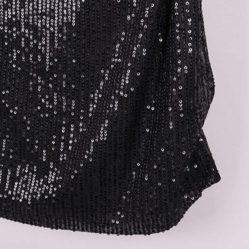 Närbild på nedre delen av svart paljettopp