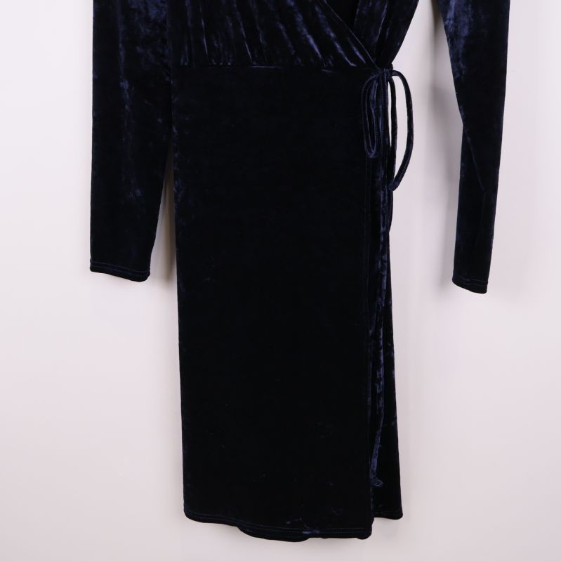Nedre delen av svart sammetsklänning med knytband i midjan
