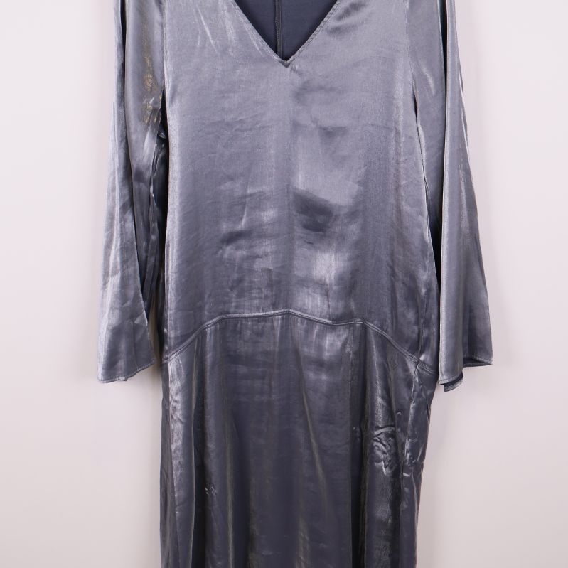 Mittenparti av glansig långärmad klänning i silverblå ton med sömdetalj