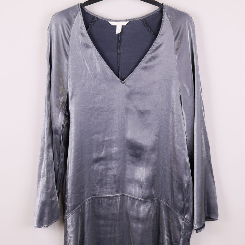 Närbild på överdelen av den silvriga klänningen med v-ringning