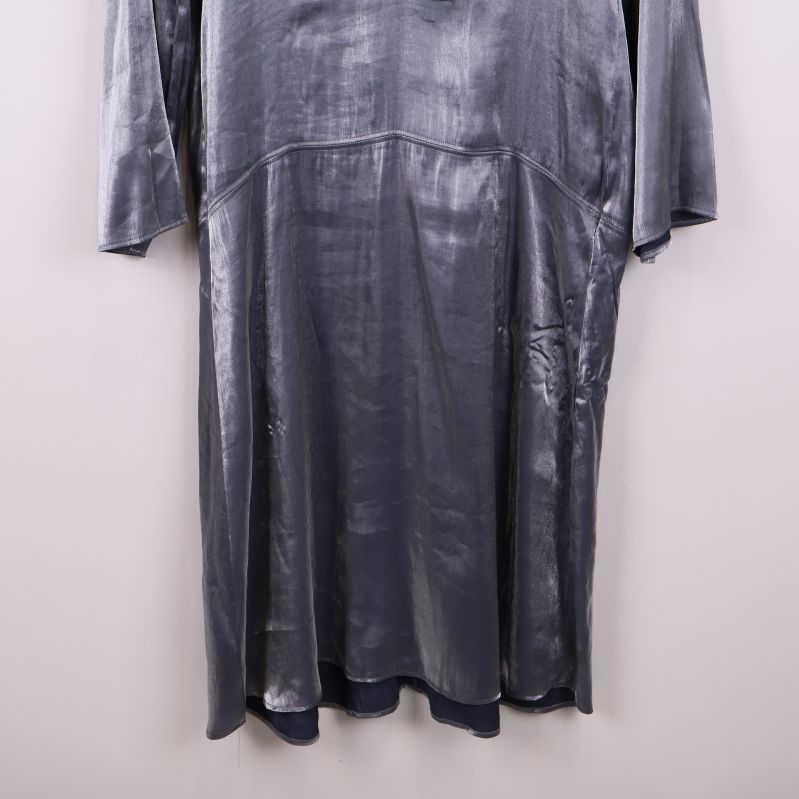 Nedre delen av glansig klänning med lätt glansig yta