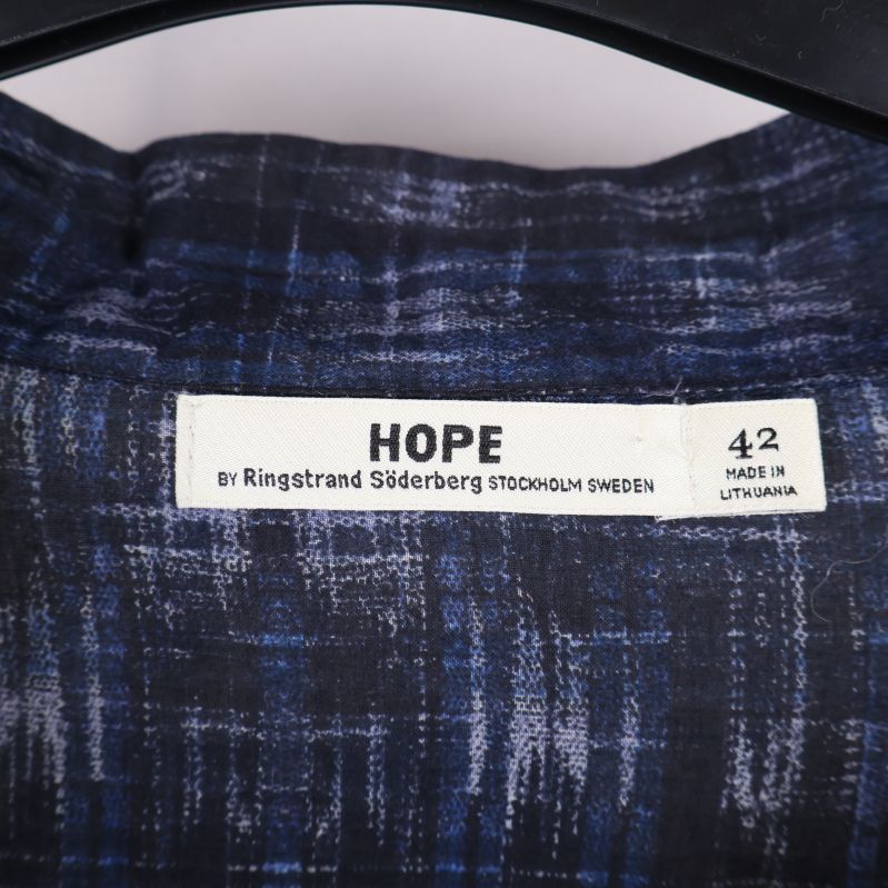 Närbild av HOPE-etikett och storlek 42 i blusen