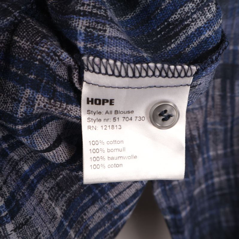 Materiallapp som visar 100% bomull på HOPE-blus