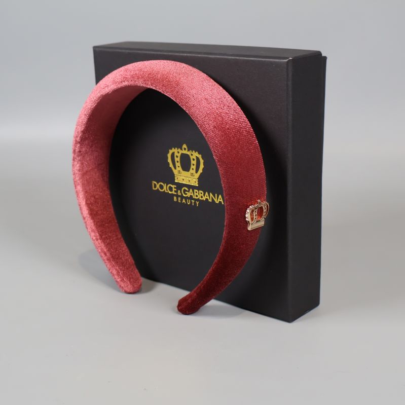 Gammelrosa sammetsdiadem framför Dolce & Gabbana svart box
