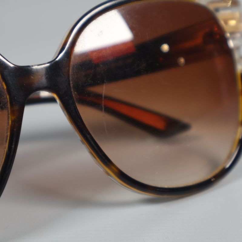 Närbild på repiga bruna glas i solglasögon