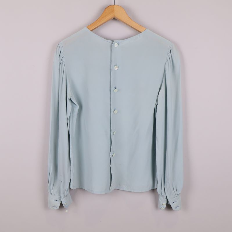 Baksida av blus med knappar längs ryggen