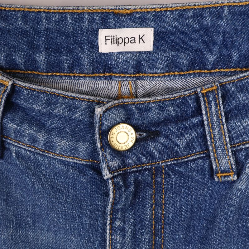 Filippa K logotyp och knapp på jeansens linning