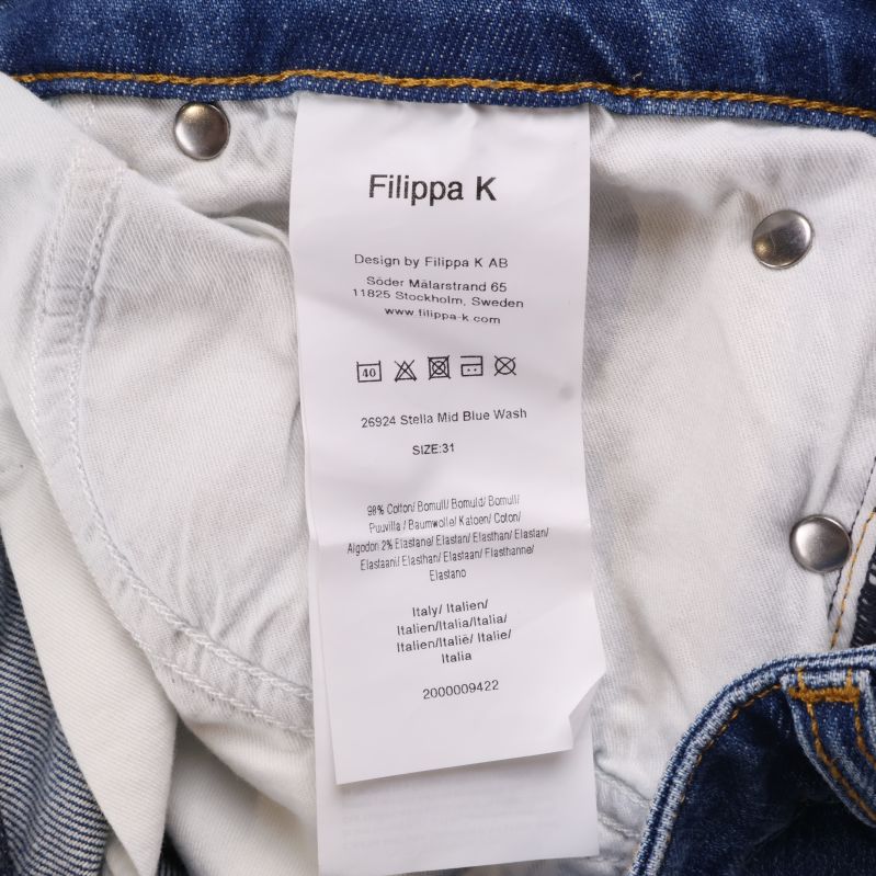 Materialetikett med Filippa K och tvättråd inuti jeansen