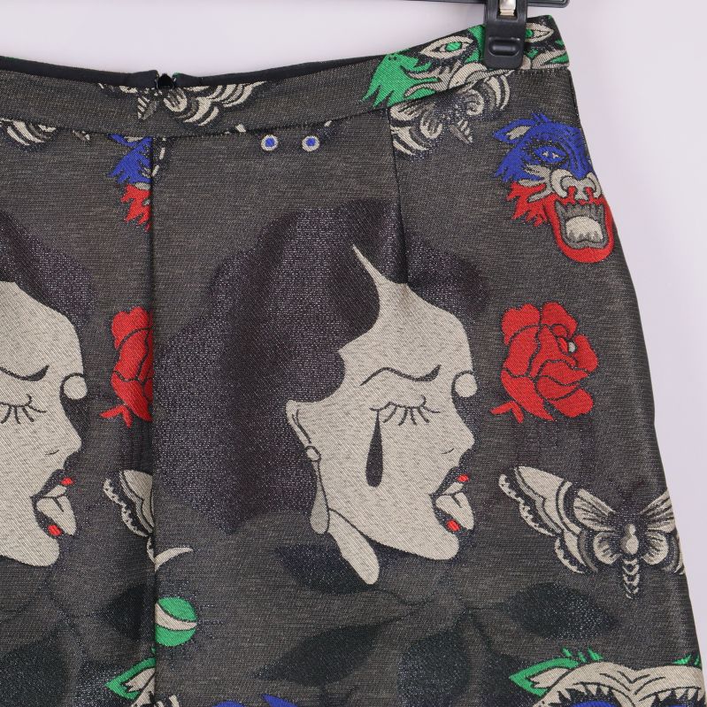 Närbild på kjolens mönster med kvinnoansikte och röda rosor