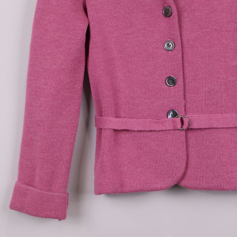 Detaljbild på ärmslut och midjebälte på rosa kavaj