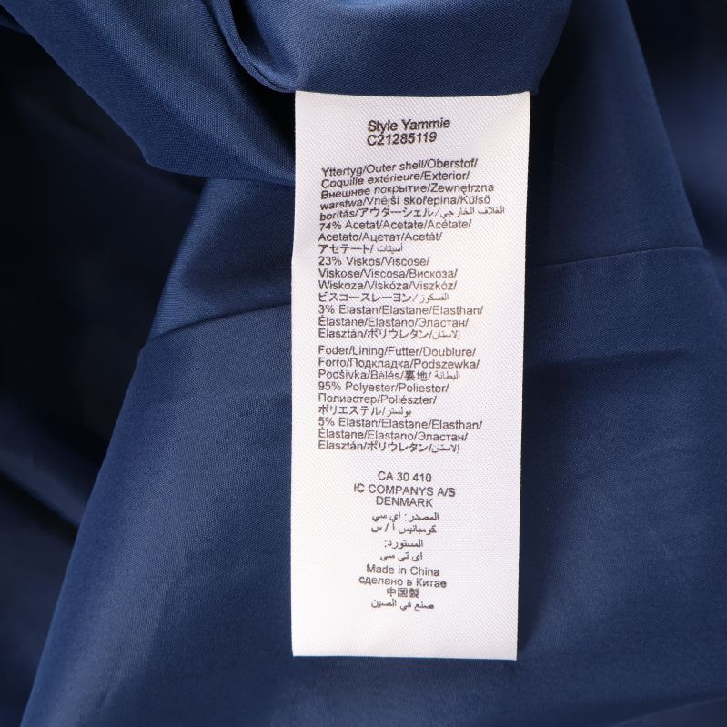 Materiallapp med information om tygsammansättning i klänningen