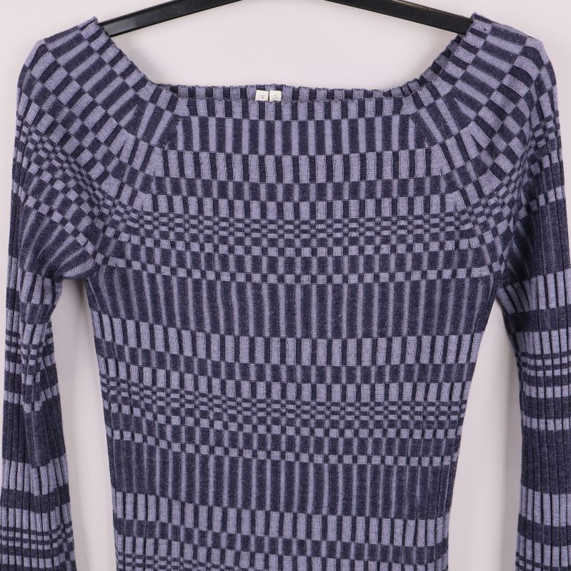 Närbild på fyrkantig halsringning och stickat mönster