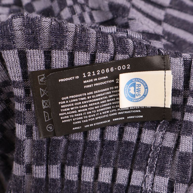 Material- och vårdlapp på insidan av plagget